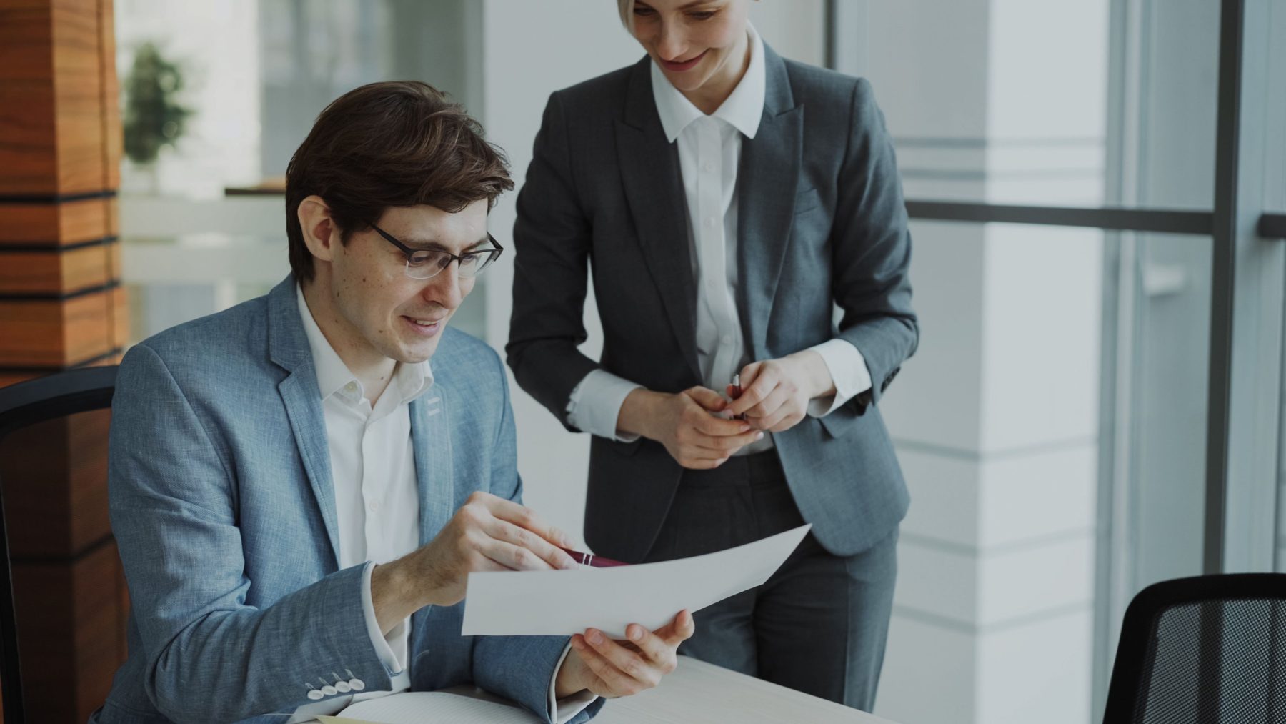 An accountant going through a document with a client at a desk